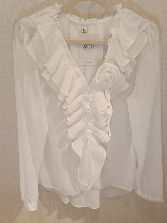 Blusa blanca con chorreras y flor